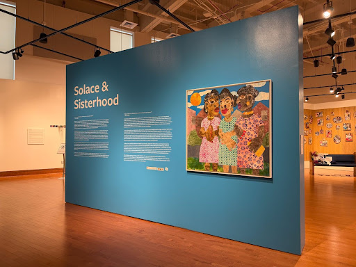 A wall with artwork titled 'Solace & Sisterhood' 