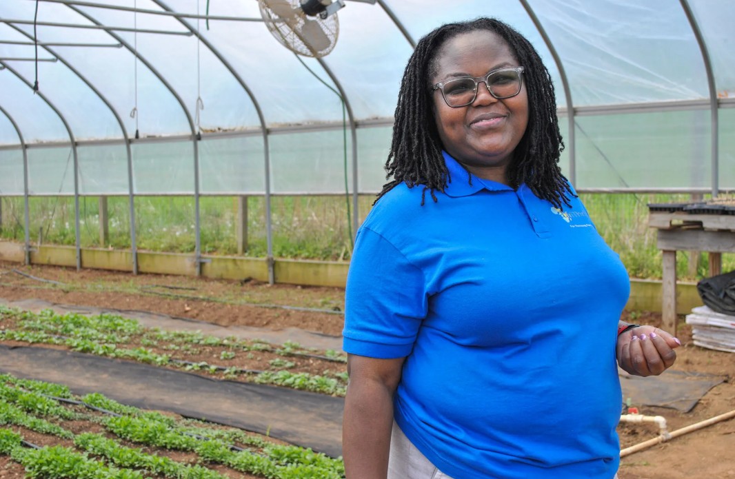 AfriThrive CEO Truphena Choti Ph.D. ’09 stands inside the greenhouse.
