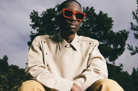 man with red sunglasses in front of trees