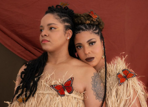 two women against a maroon backdrop