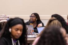 People sitting and one has microphone