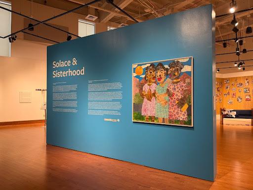 A wall with artwork titled 'Solace & Sisterhood' 